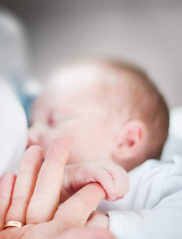 Support Breastfeeding: Image of infant holding adults finger