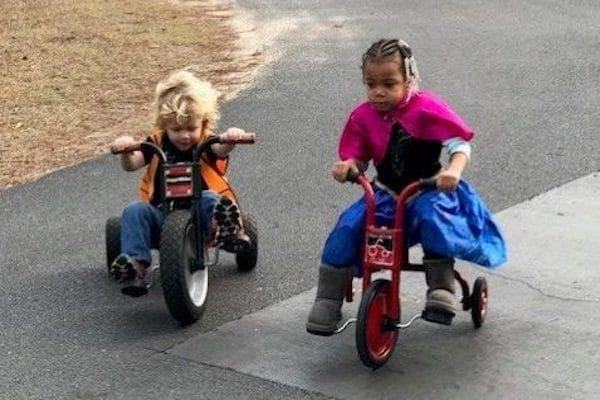 children playing outside on tricycles